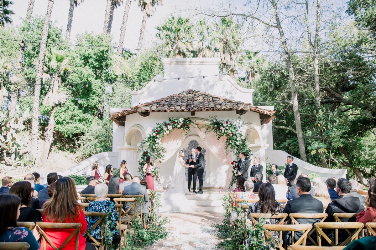 Outdoor wedding ceremony at a garden venue with guests
