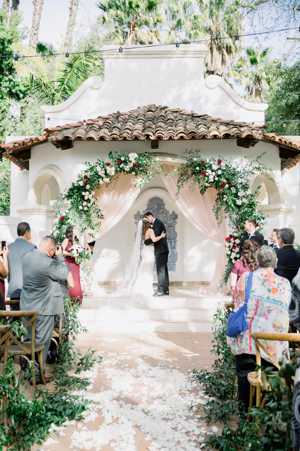 Bride and groom kissing at an outdoor floral wedding