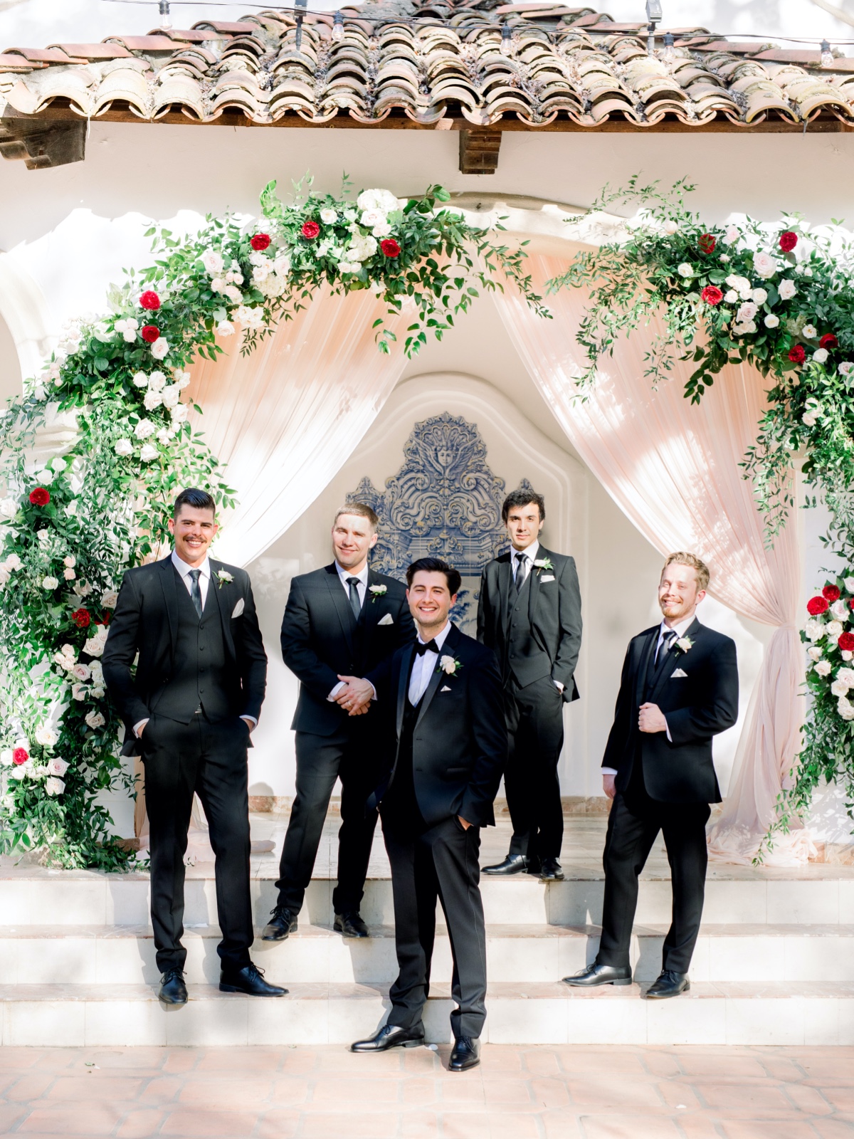 Groom with groomsmen in black suits at wedding venue