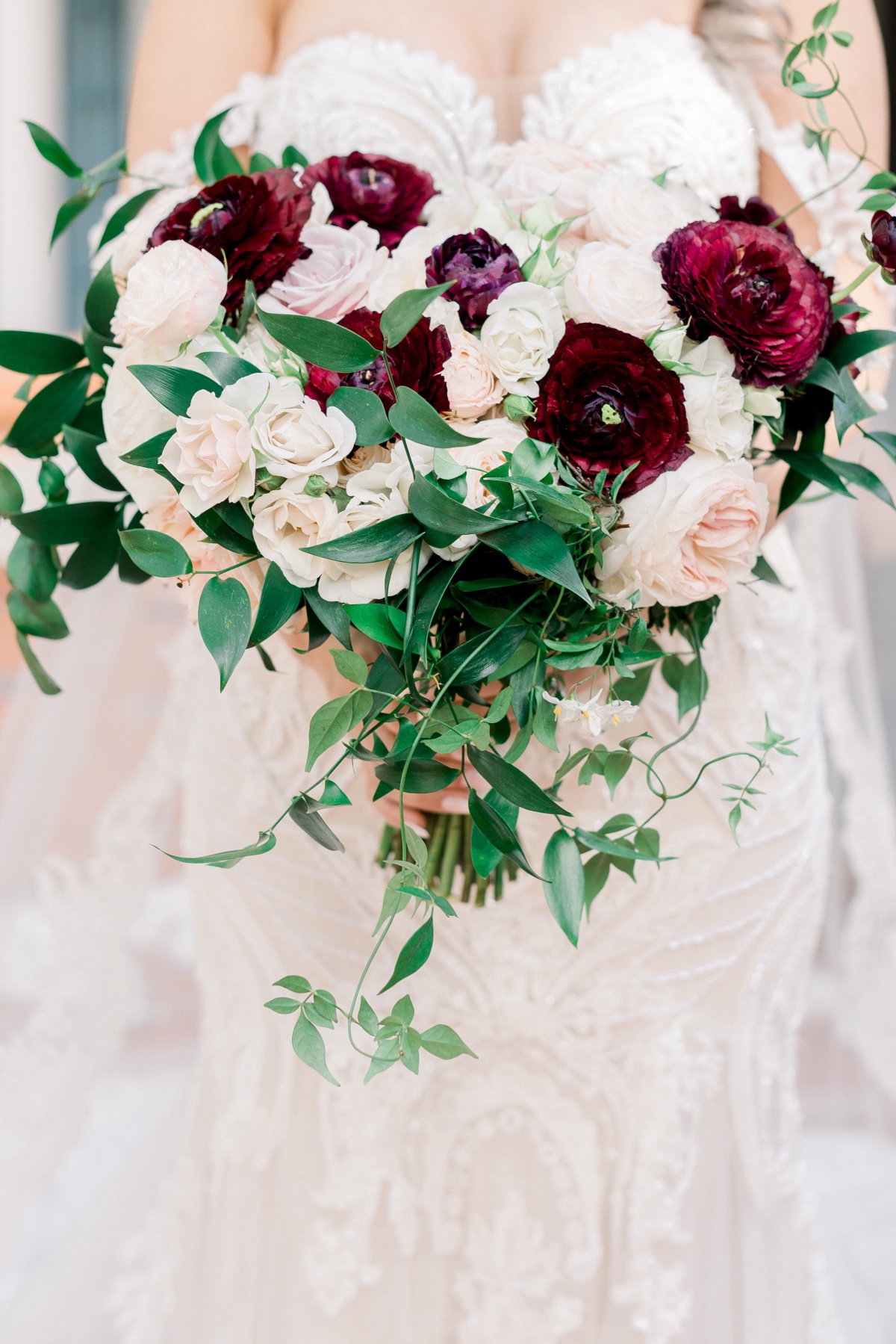 Bride holds a stunning burgundy and ivory wedding bouquet