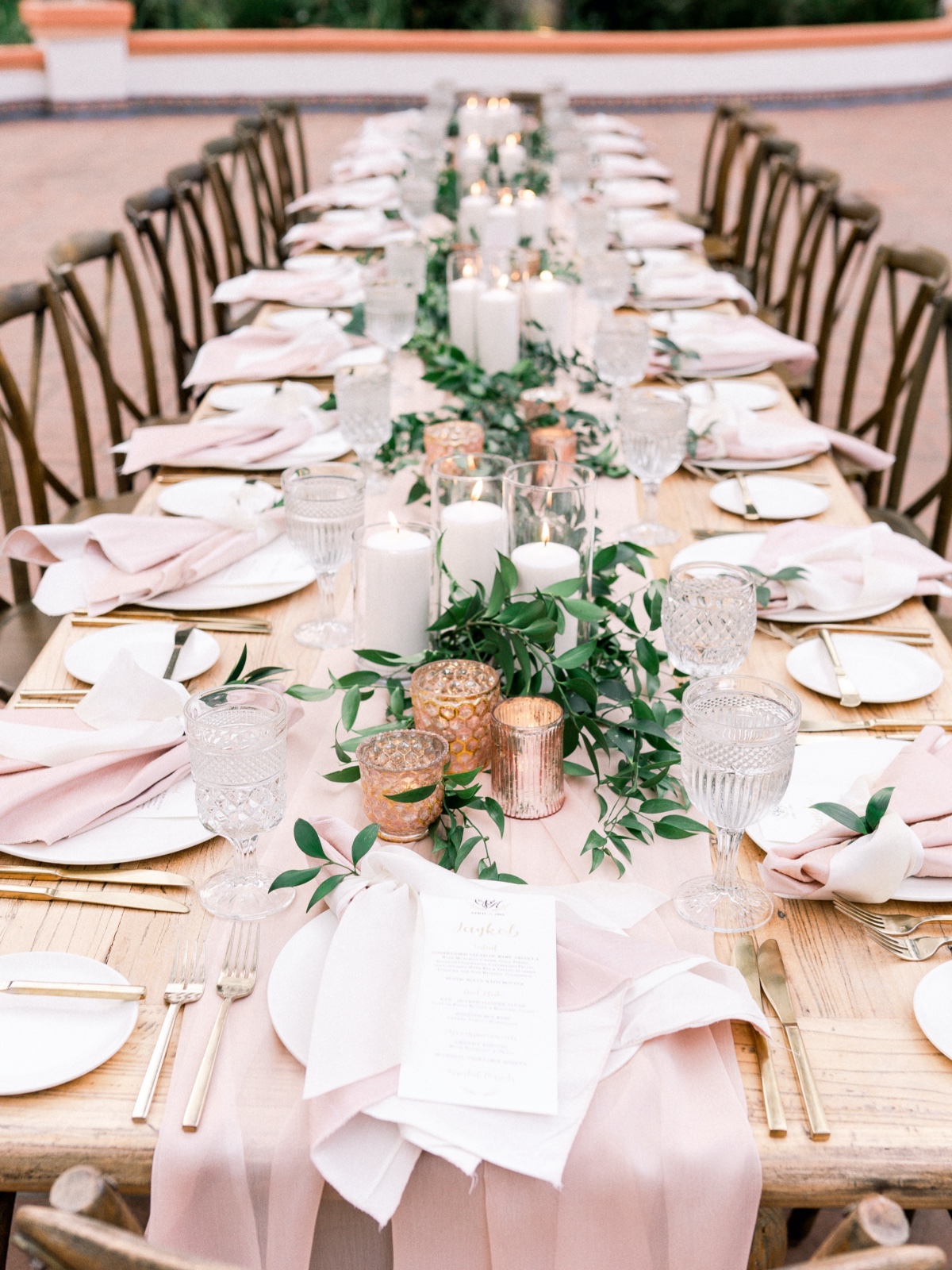 Elegant wedding reception table setting with candles greenery
