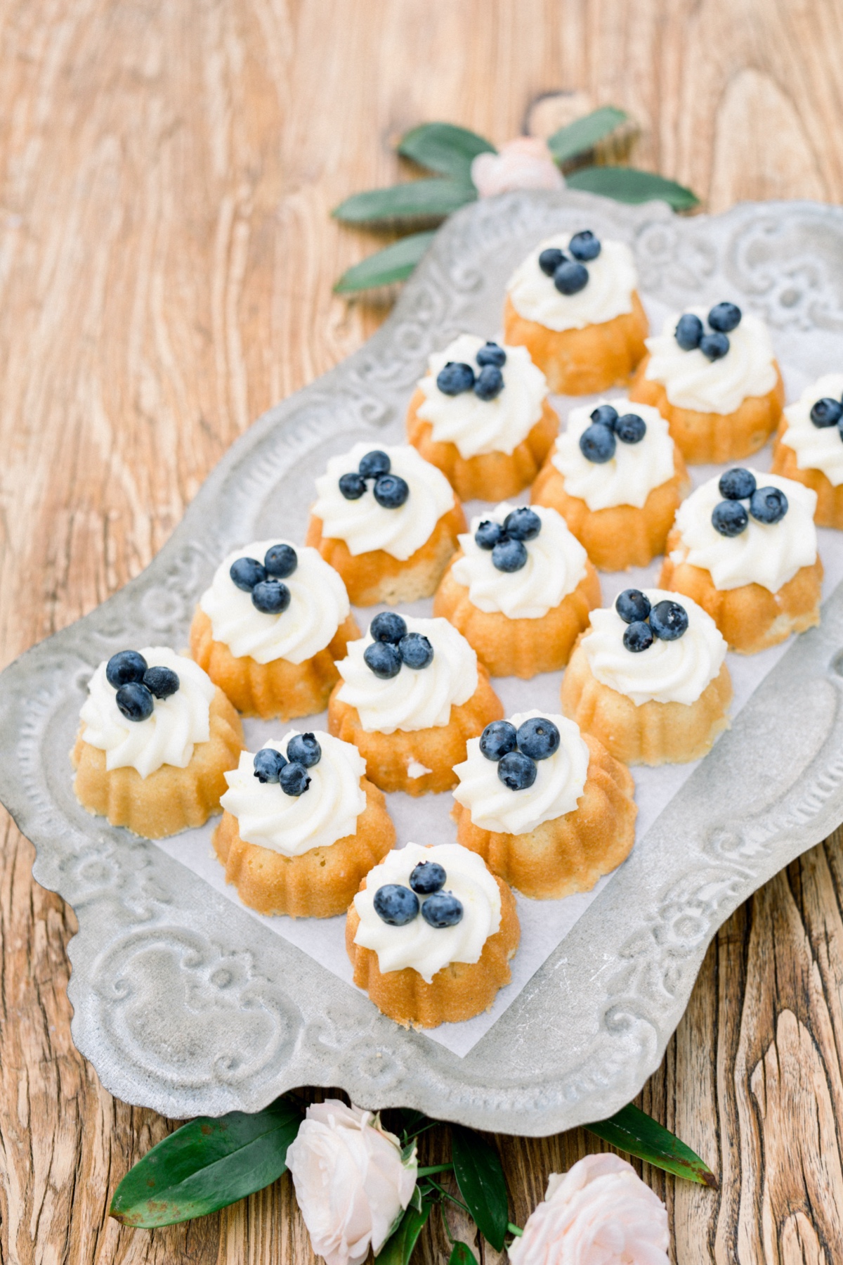 Mini bundt cakes with cream and blueberries on a tray