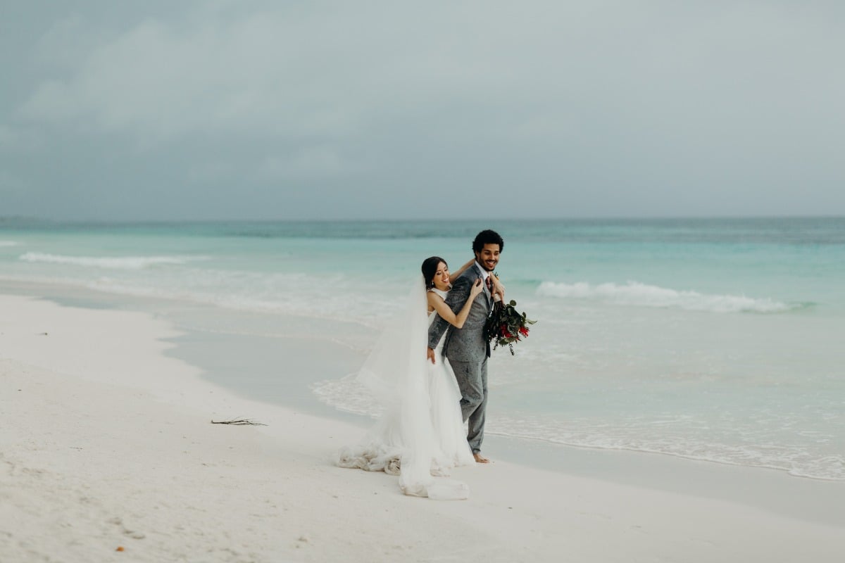 bride and groom walking on beach in Tulum, Mexico