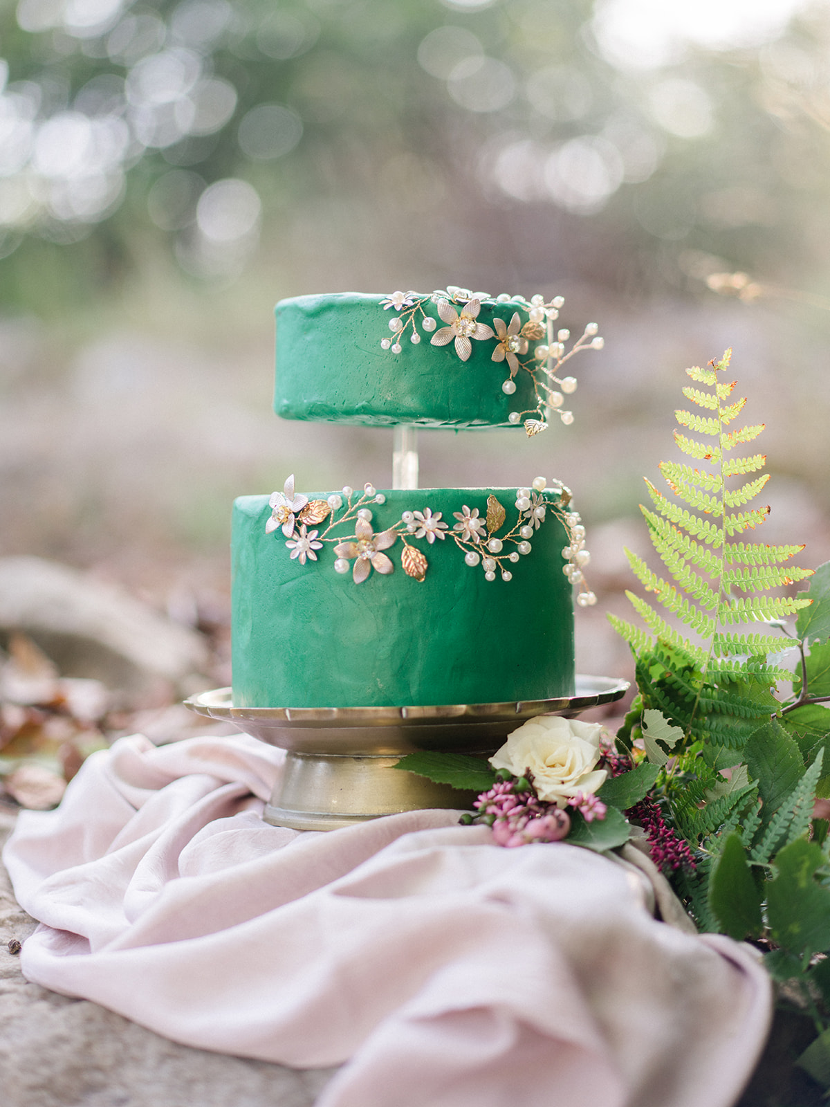 green wedding cake on gold cake stand