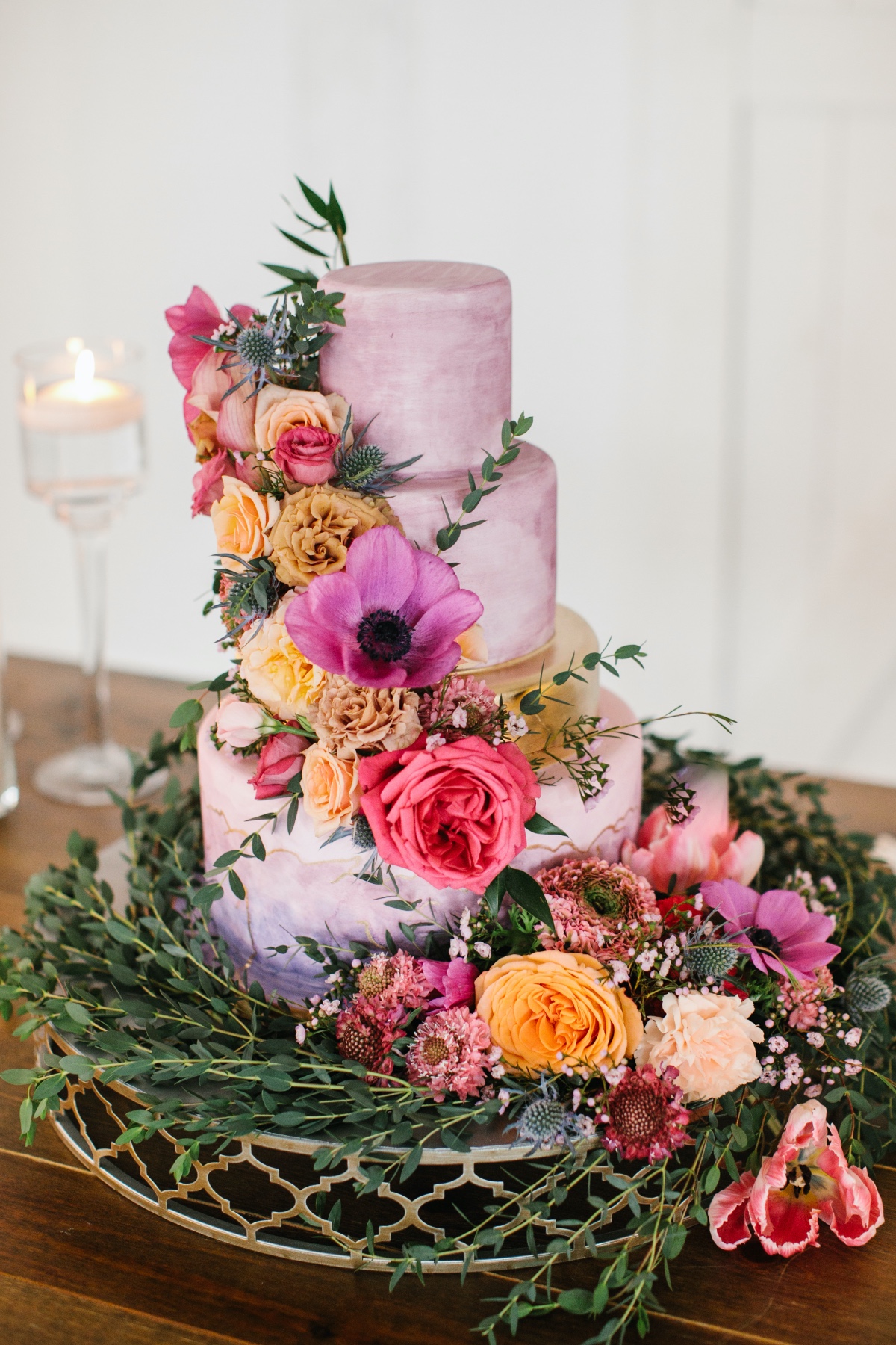 purple watercolor wedding cake adorned with florals from Baked in Nashville