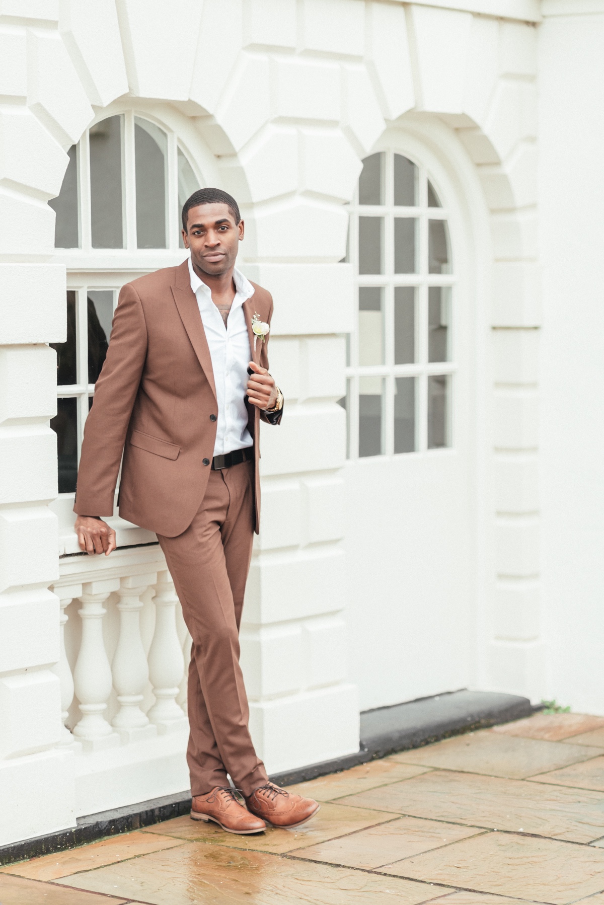 Groom in brown suit with brown shoes and pink boutonniere