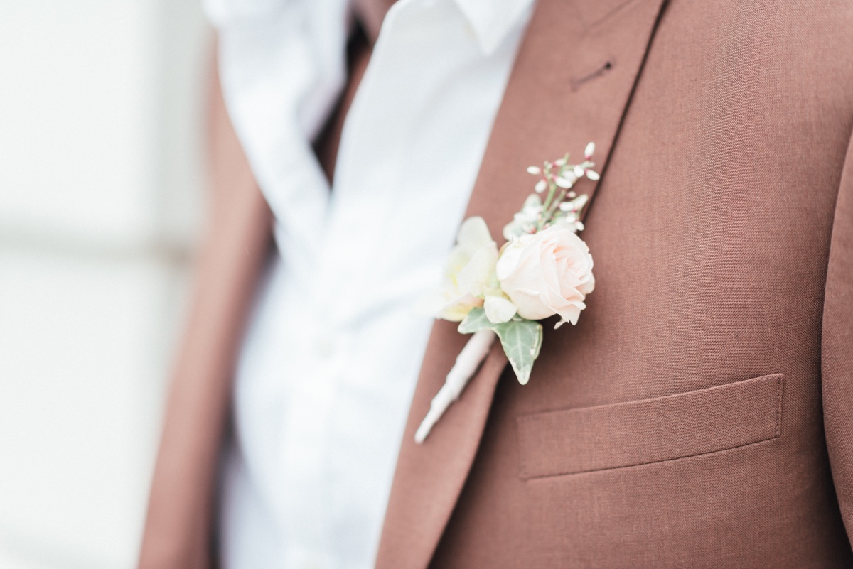 pink boutonniere  paired with brown suit