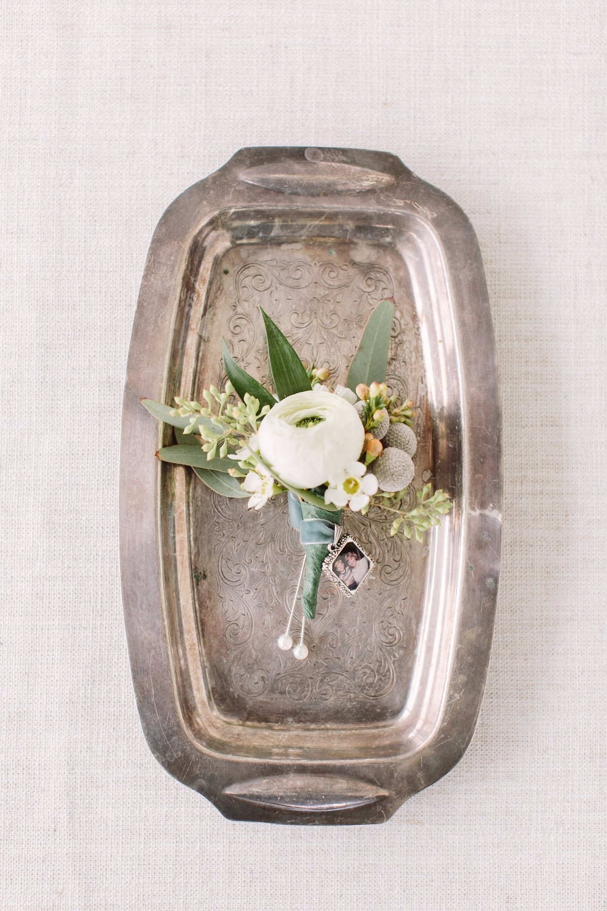 white boutonniÃ¨re with small photo placed on it