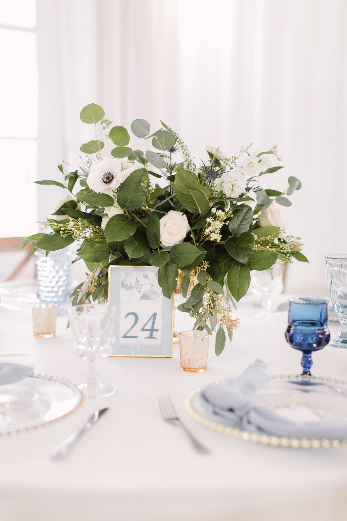 white and blue table decor with green and white floral arrangement