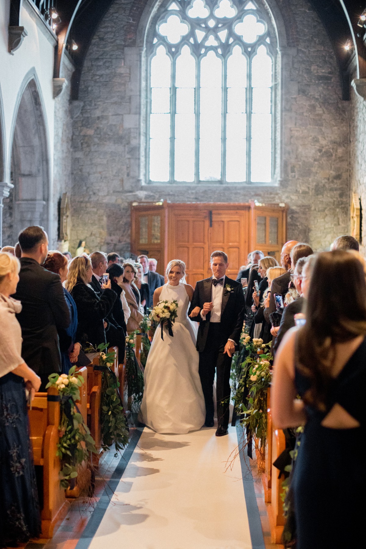 Bride walks with father down church aisle on wedding day