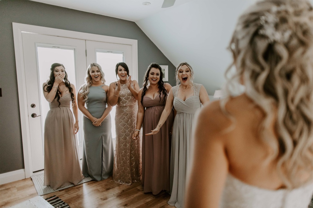 bridesmaids seeing bride for the first time in her wedding dress