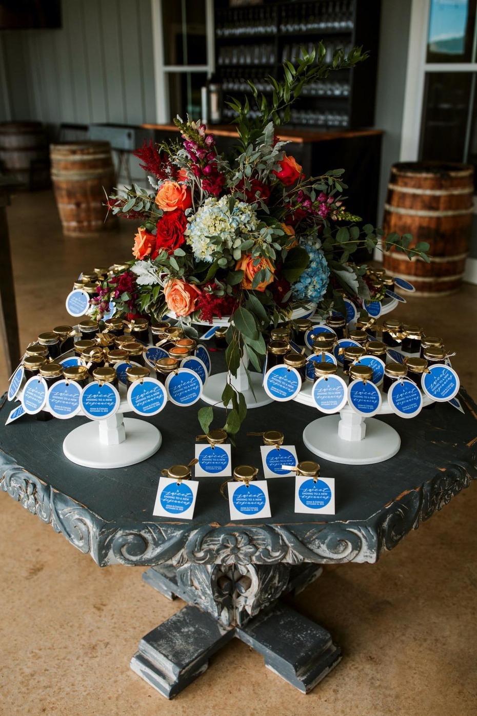 Wedding favors jars under floral arrangement on table