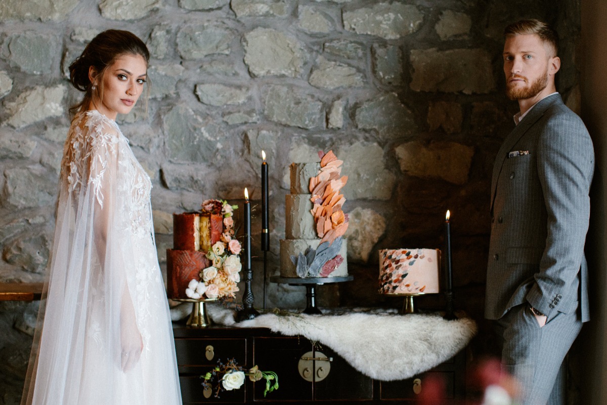 Bride groom and wedding cakes rustic backdrop indoors