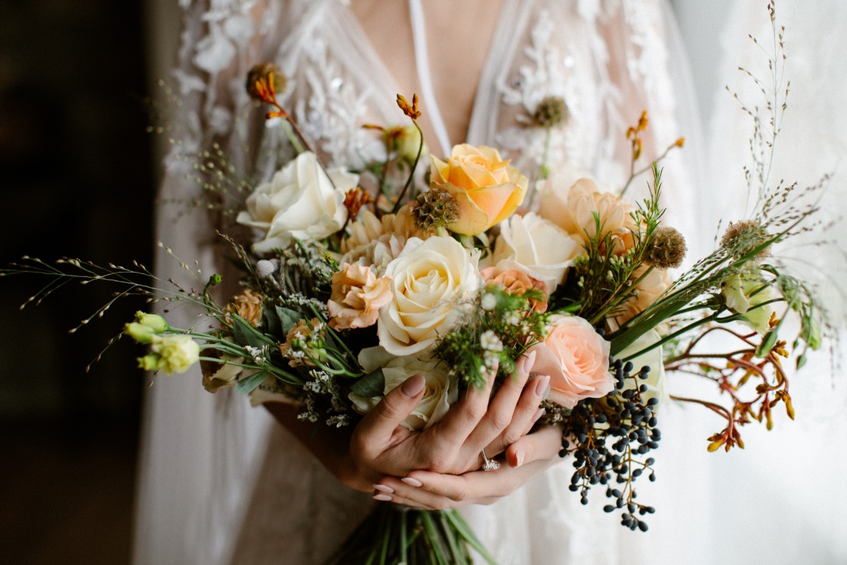 Elegant bride holding a beautiful bouquet of colorful wedding flowers