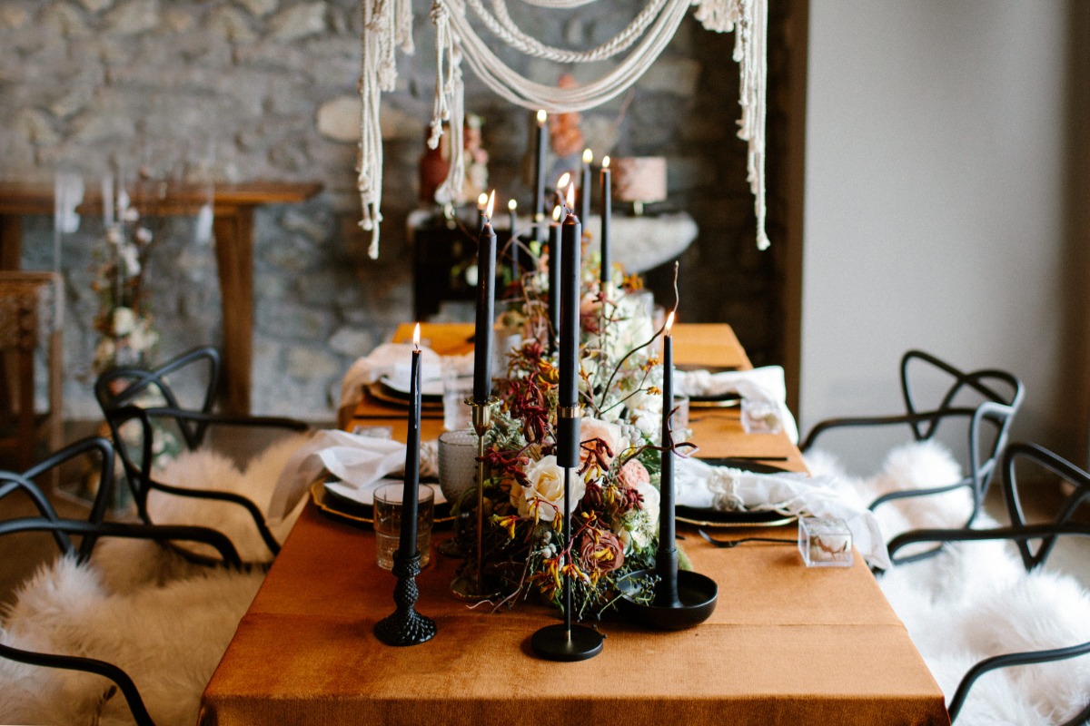 Elegant table setting with candles, flowers, and boho decor