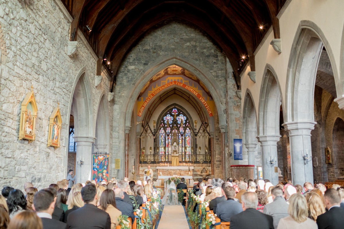 Wedding ceremony in old stone church with stained glass