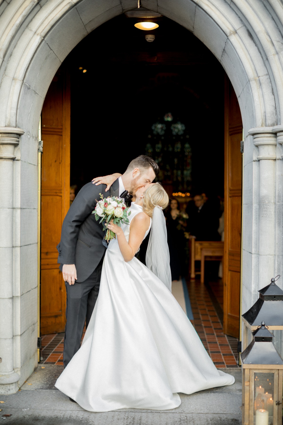 Newlyweds share a kiss at their church wedding exit