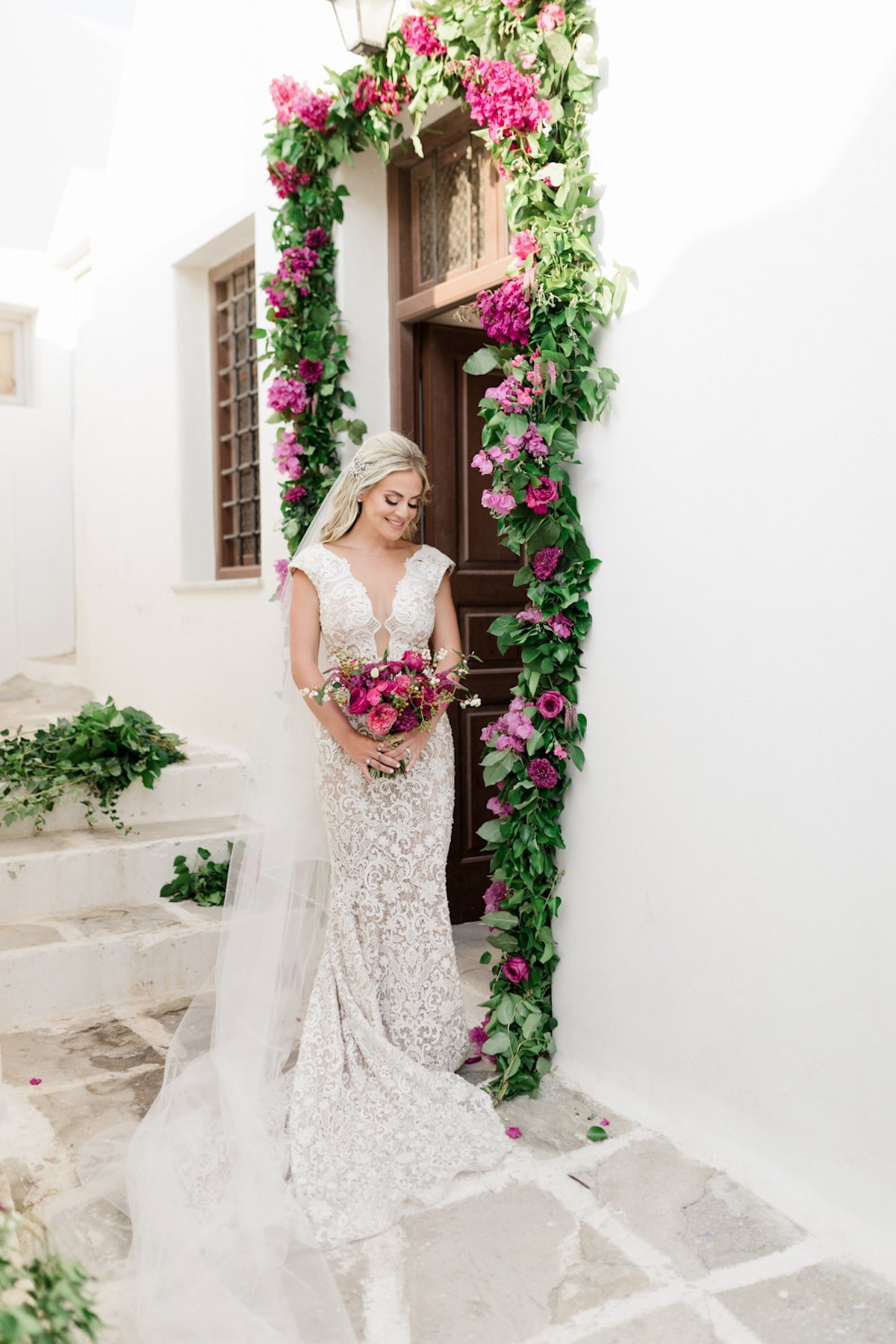 bride in door way adorned with greener and magenta florals
