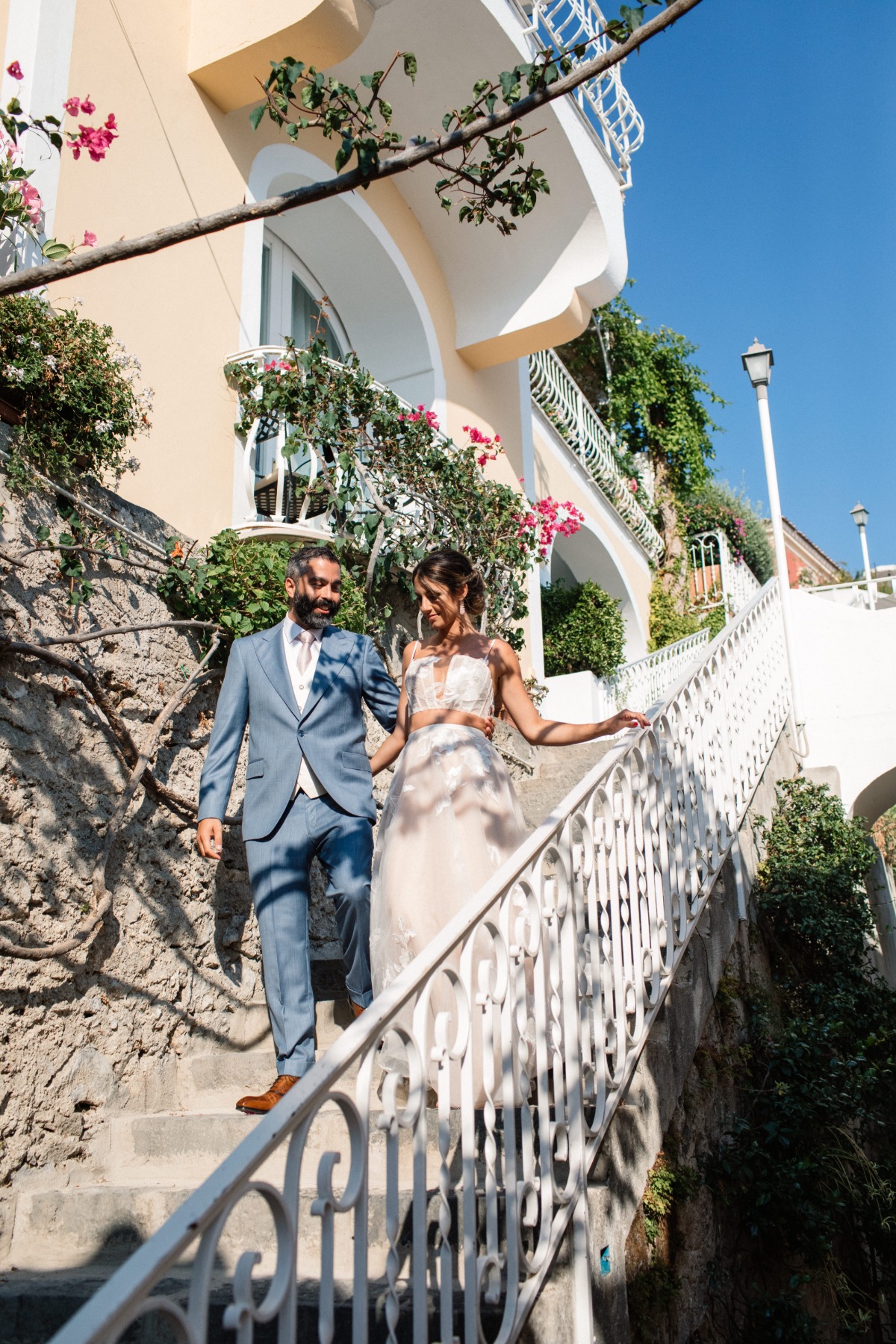 Newlyweds descend stairs on their wedding day in sunny Italy