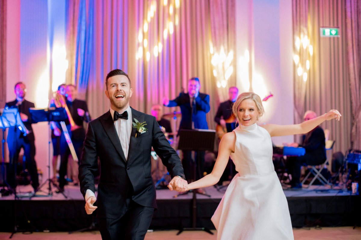 Happy bride and groom dancing with a band at their wedding reception