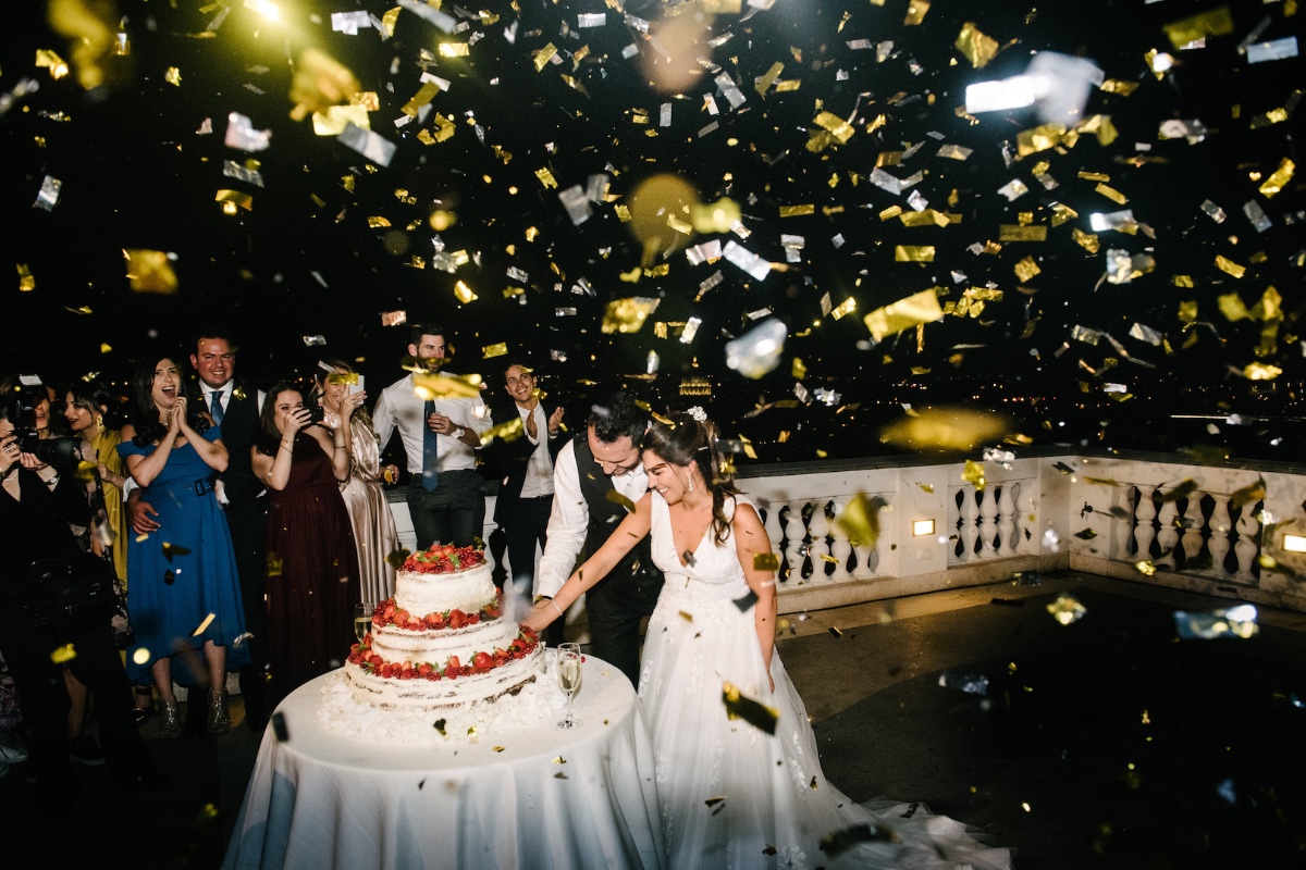 cutting of the wedding cake with a confetti toss