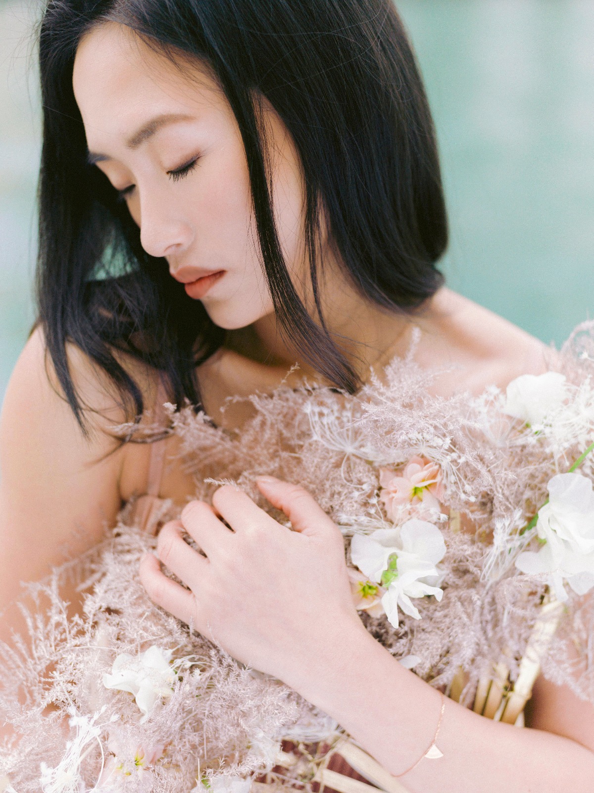 Elegant woman with closed eyes in floral dress, natural light
