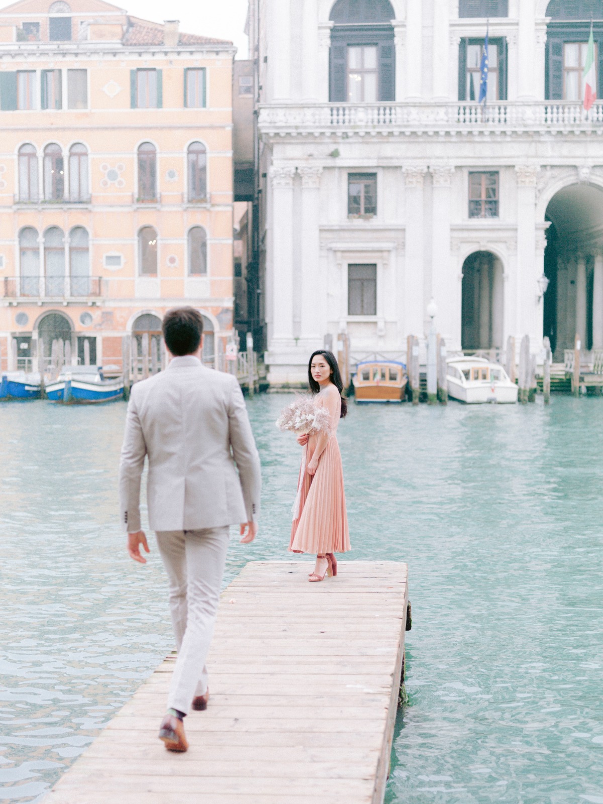 Couple in Venice walking towards each other on a pier