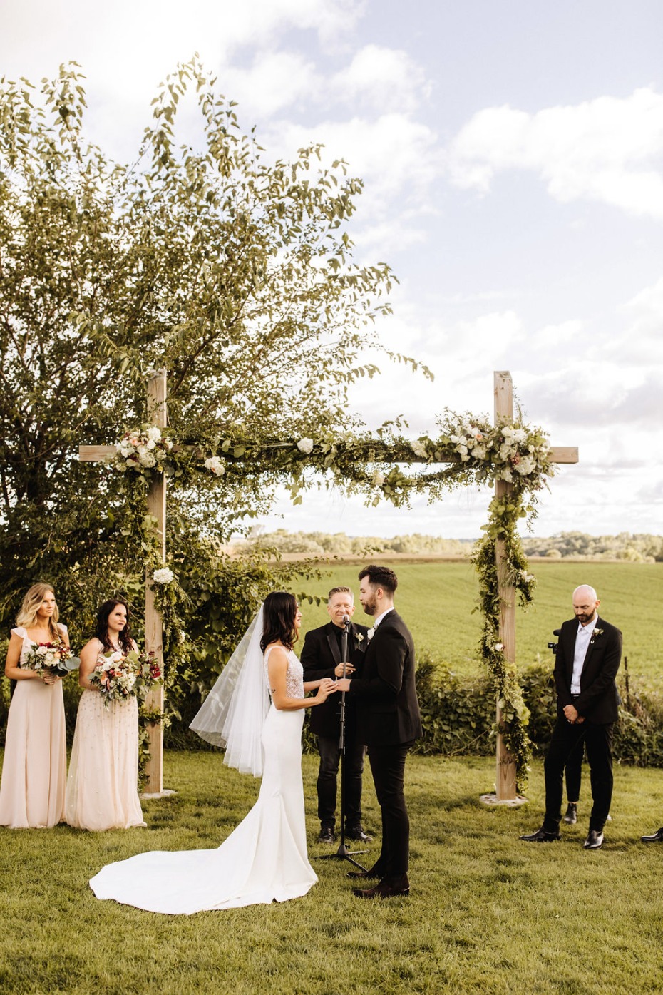 Wedding ceremony with a couple exchanging rings outdoors on a lawn