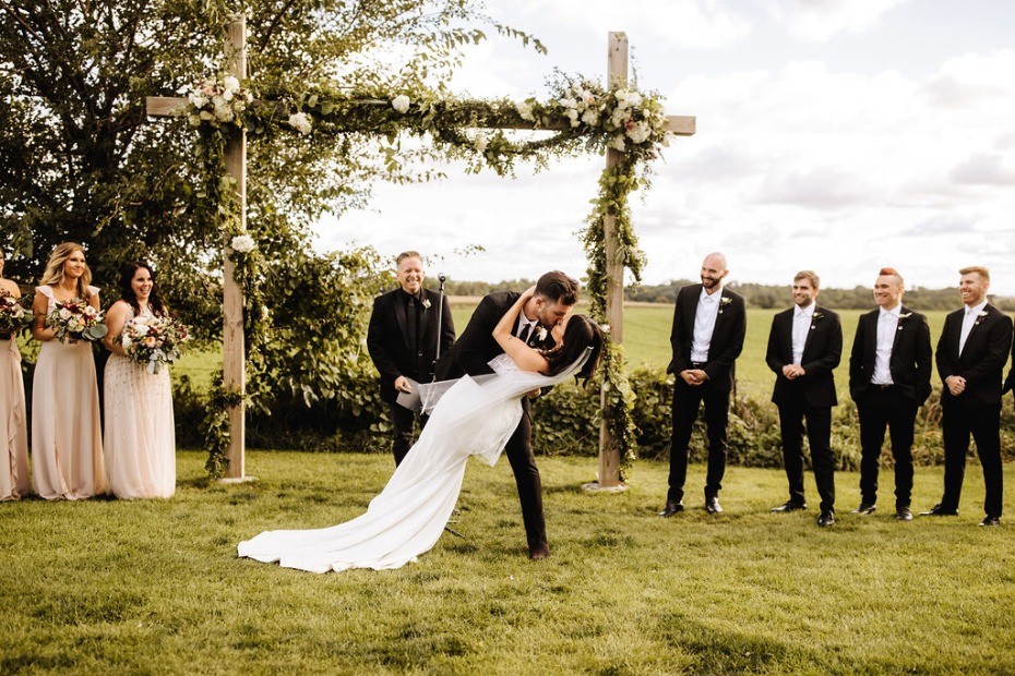 Newlyweds share a sweet kiss during their outdoor wedding ceremony