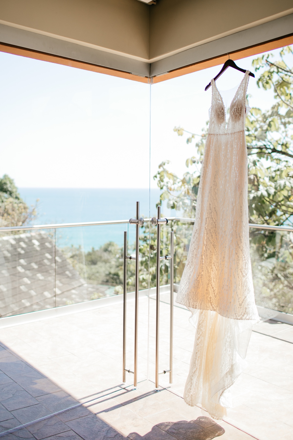 wedding dress hanging with ocean in the background