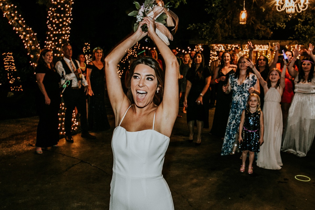 bride tossing bouquet at end of wedding at Cypress Falls Event Center