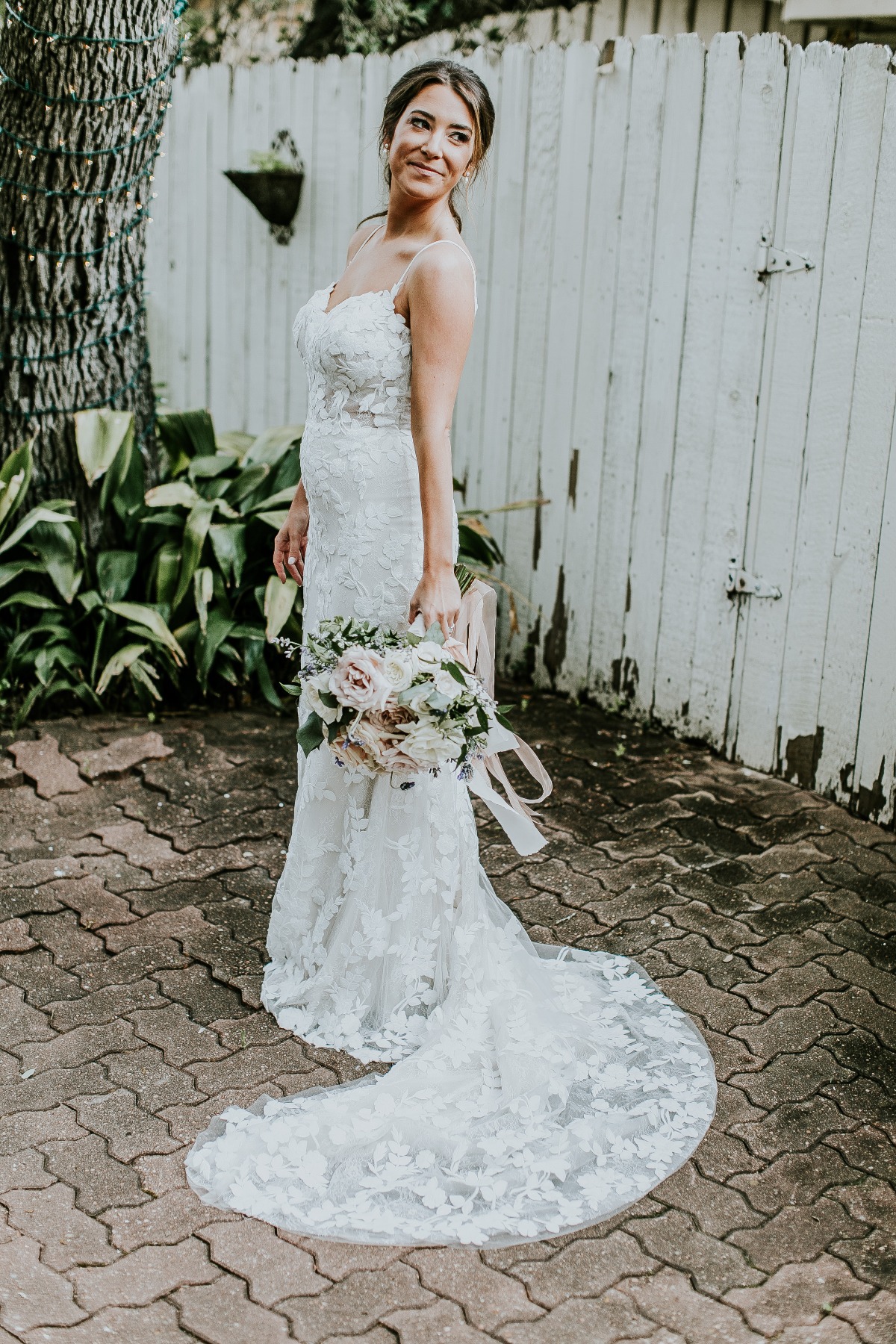bride in spaghetti strap wedding gown with blush wedding bouquet