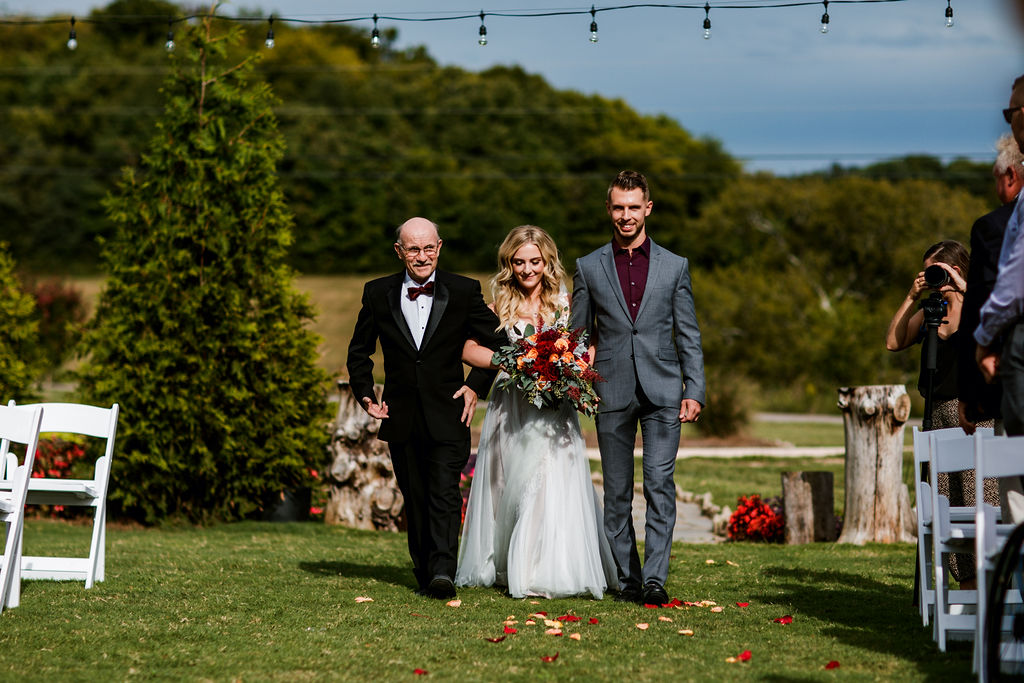 bride being walked down the aisle by Dad and brother