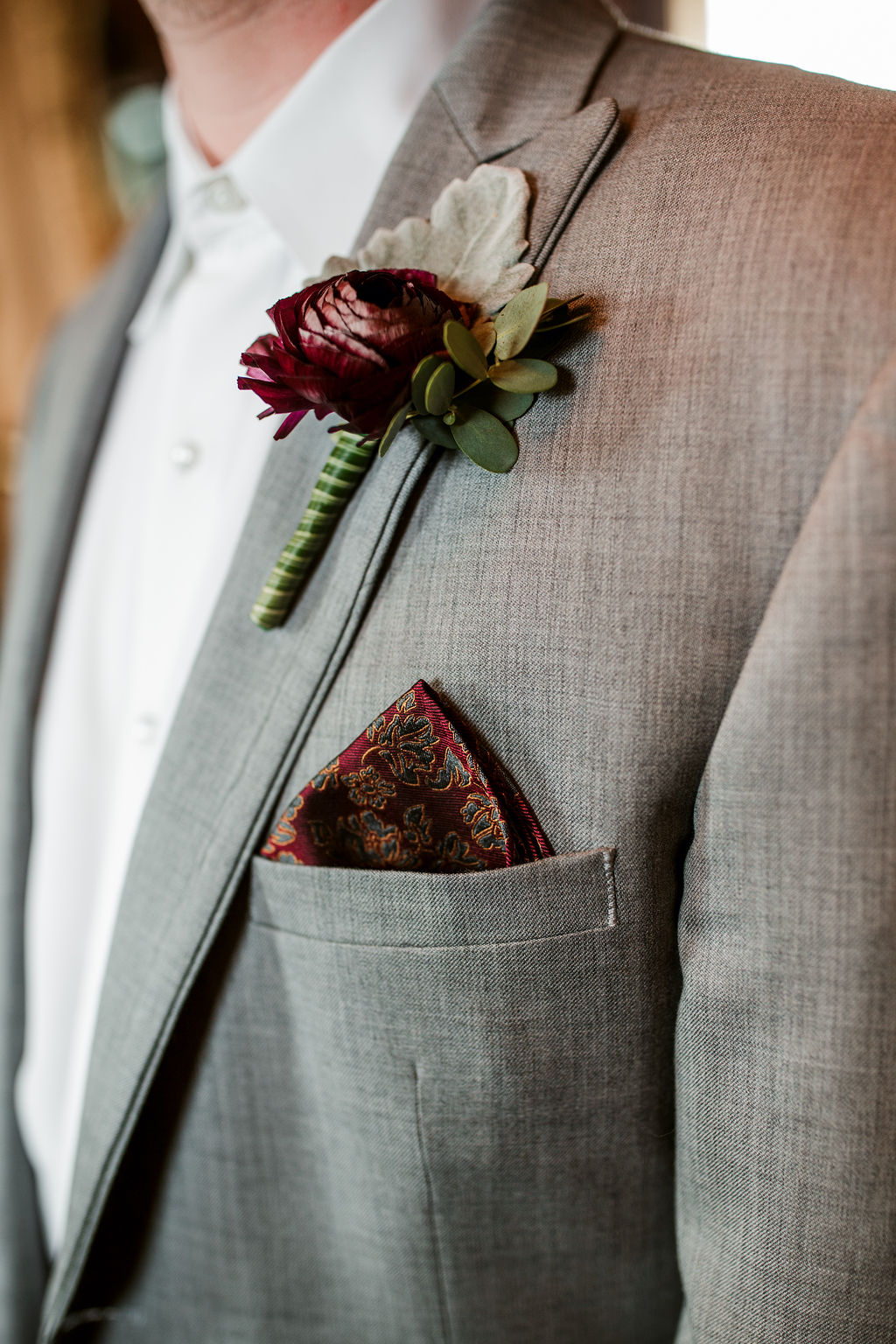Groom in gray suit with boutonniere and pocket square