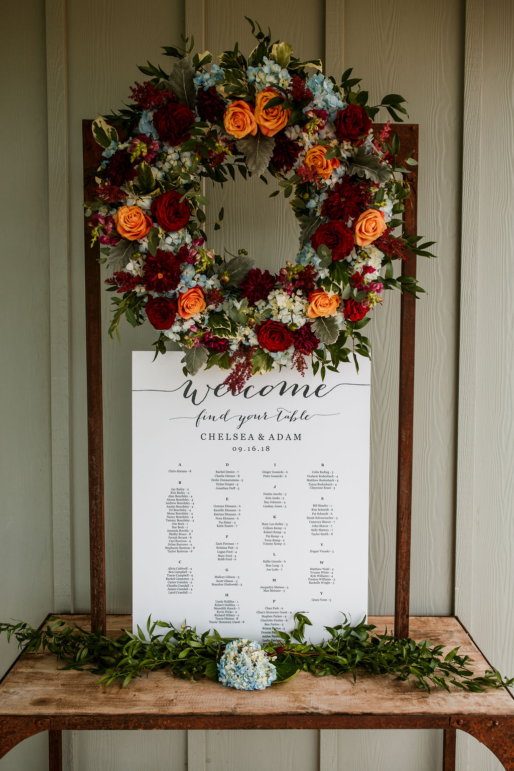 Chelsea and Adam wedding seating chart with floral wreath