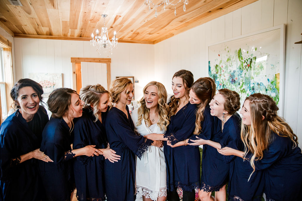 Bride and bridesmaids share a joyous moment laughing