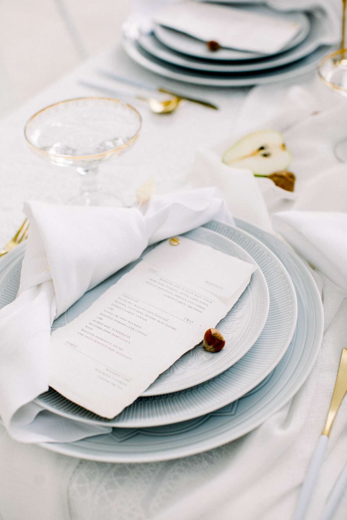 white table setting with gold cutlery and coupe Champagne glasses