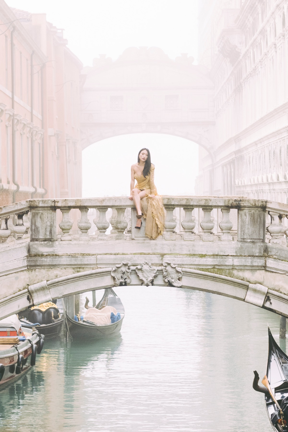Woman in gold dress on a bridge in Venice Italy