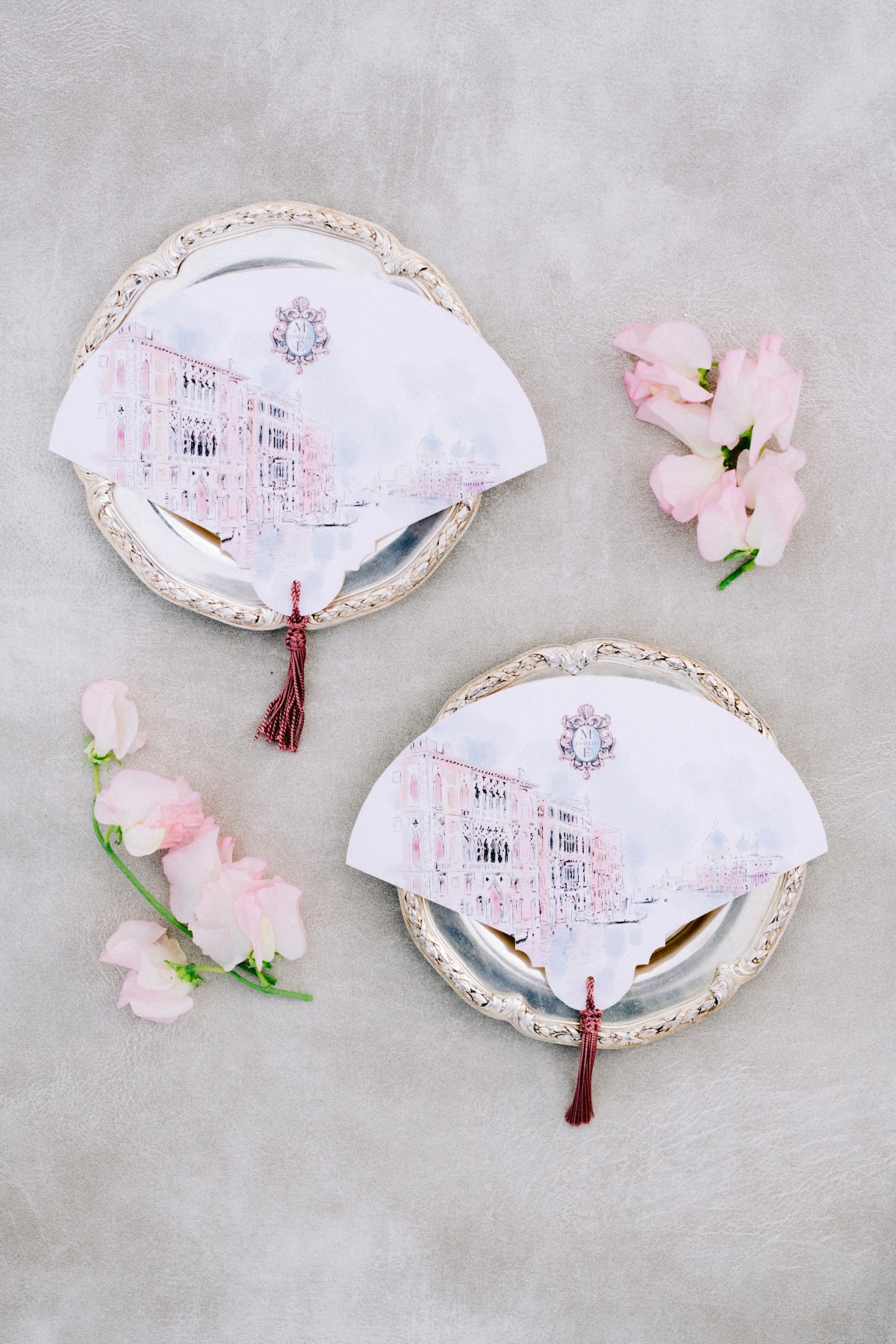 Elegant wedding invitation fans on silver trays with flowers