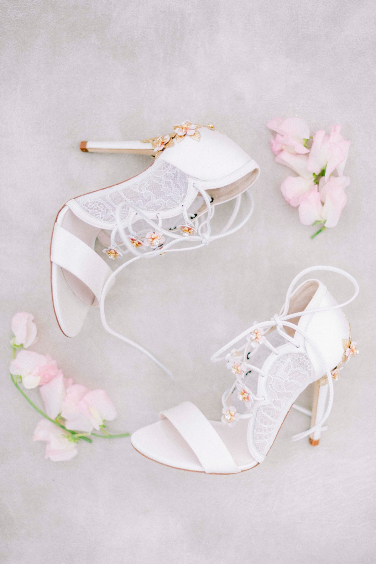Elegant white bridal heels with lace details and pink flowers