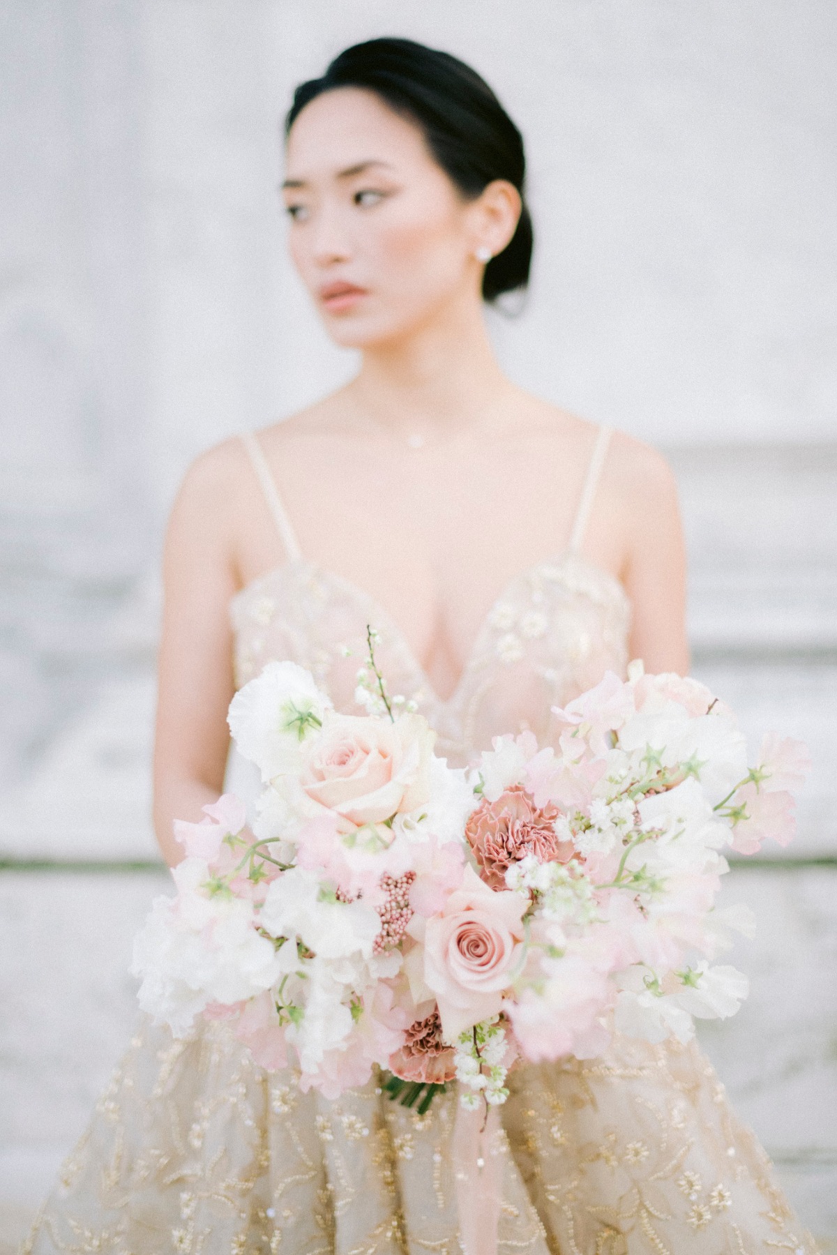 Elegant bride holding a soft blush wedding bouquet