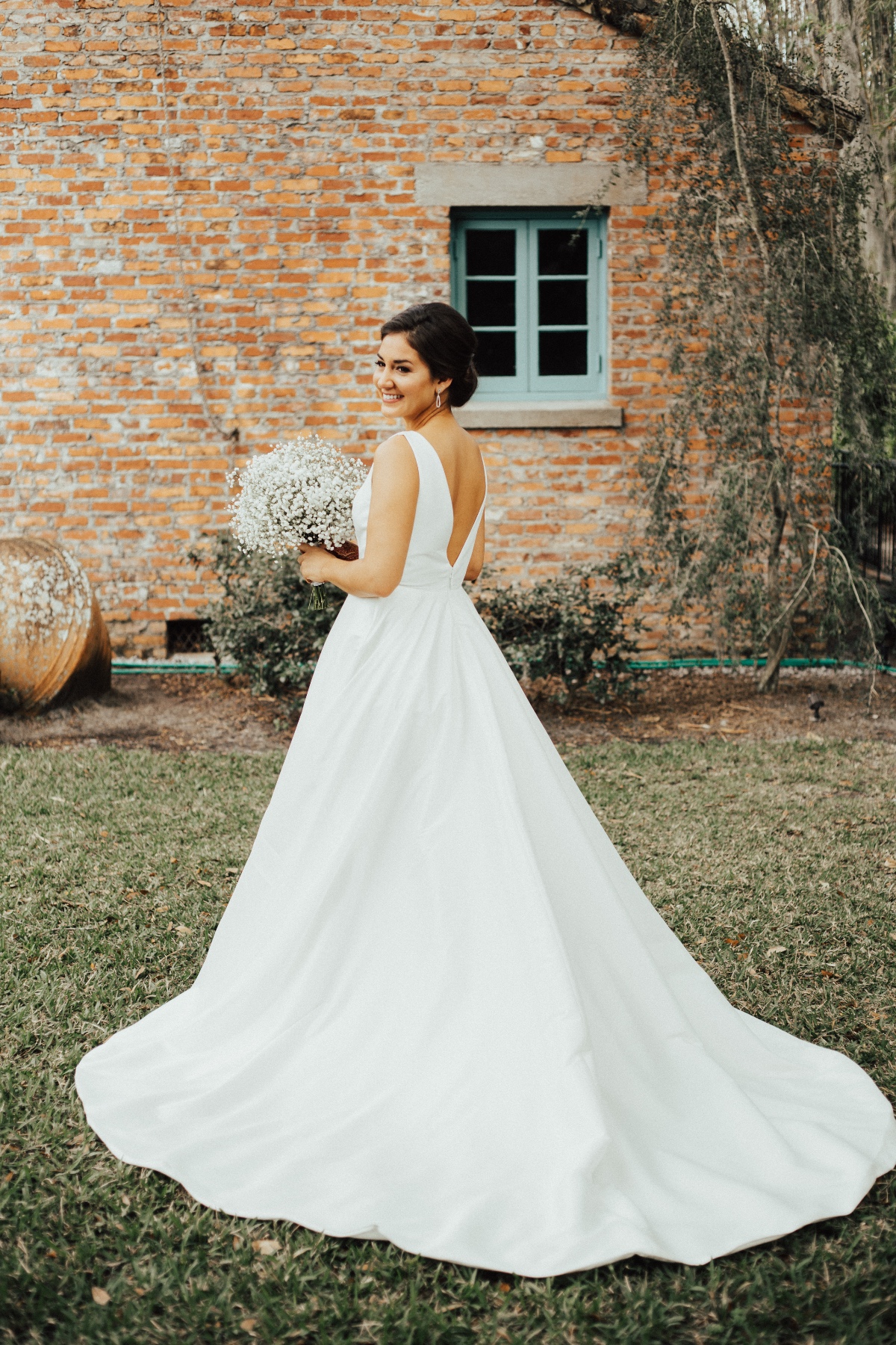 Classic Bridal Gown with thicker straps holding a baby's breath bouquet