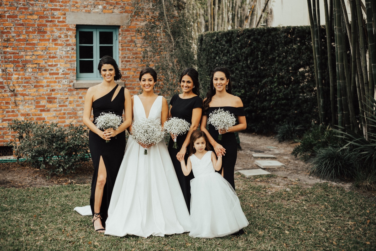 bridesmaids in black dresses with baby's breath bouquets