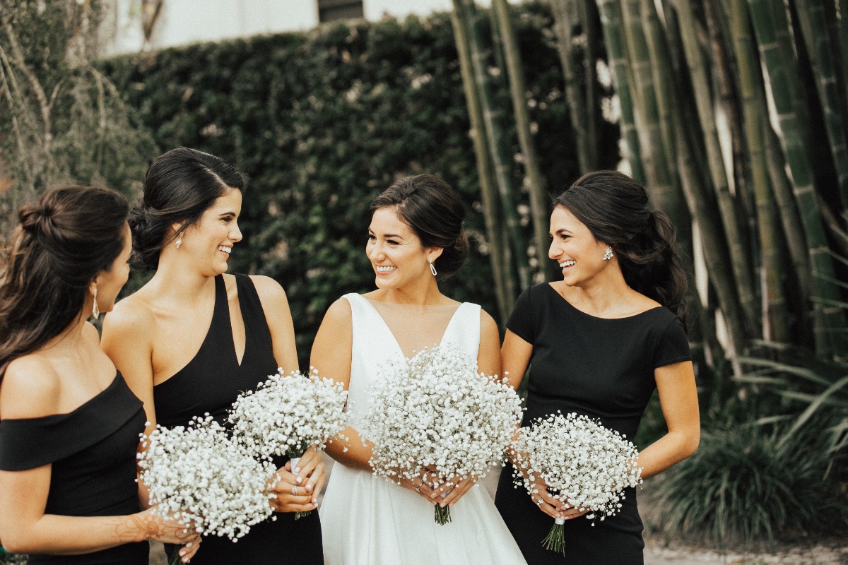 bridesmaids in black dresses with baby's breath bouquets