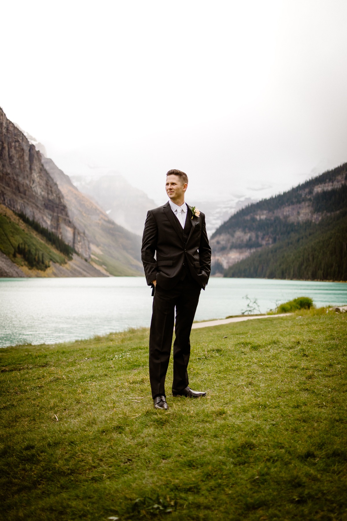 Groom in front of Lake Louise in Banff National park