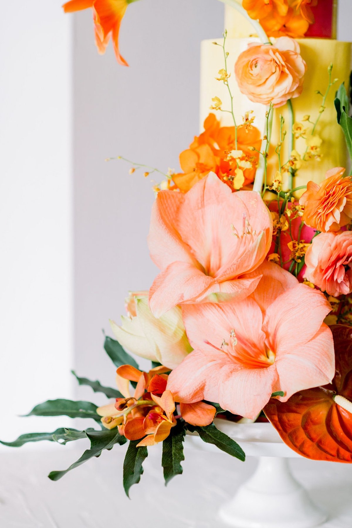 bright and colorful wedding cake adorned with tropical flowers