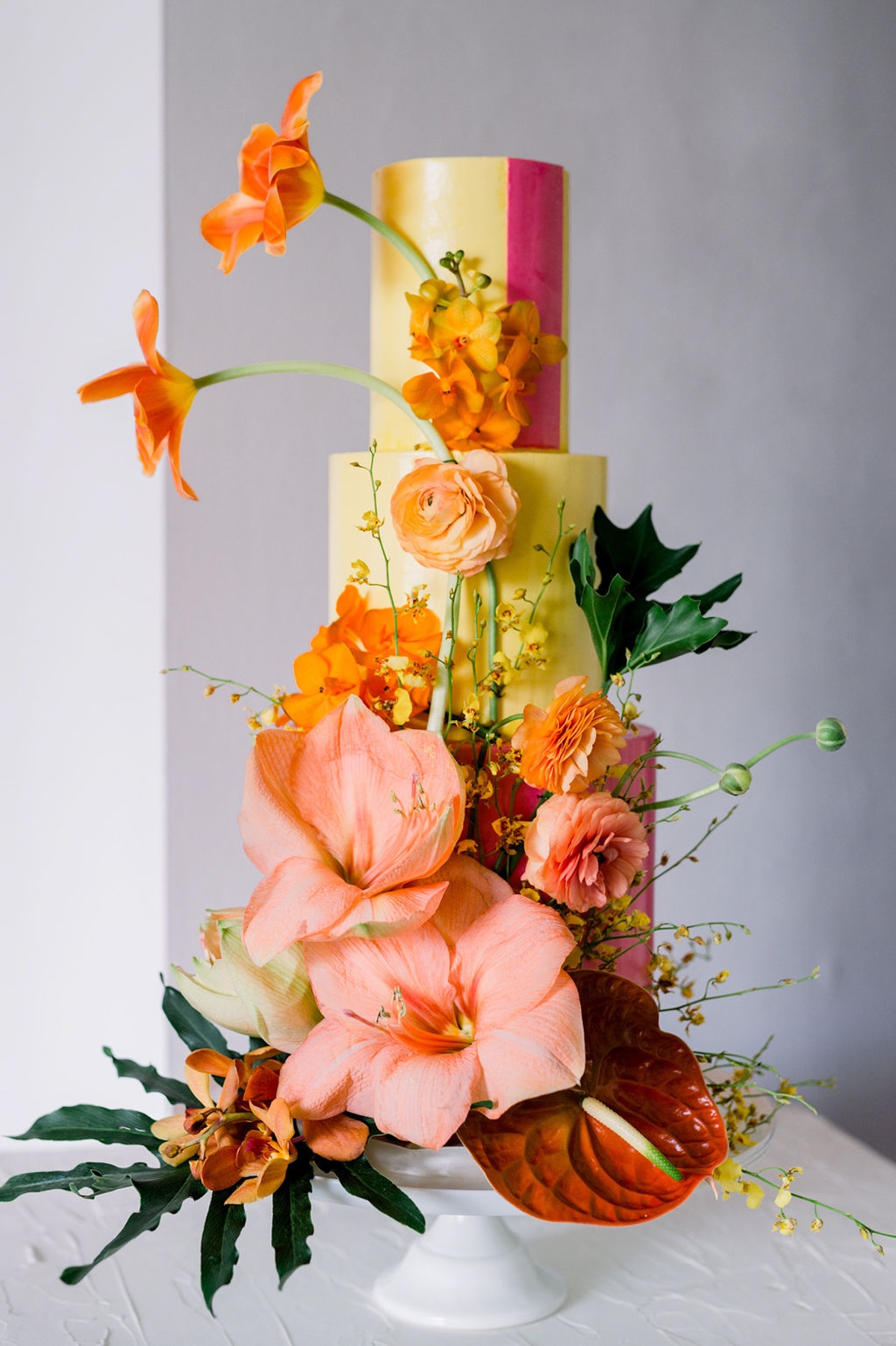 bright and colorful wedding cake adorned with tropical flowers