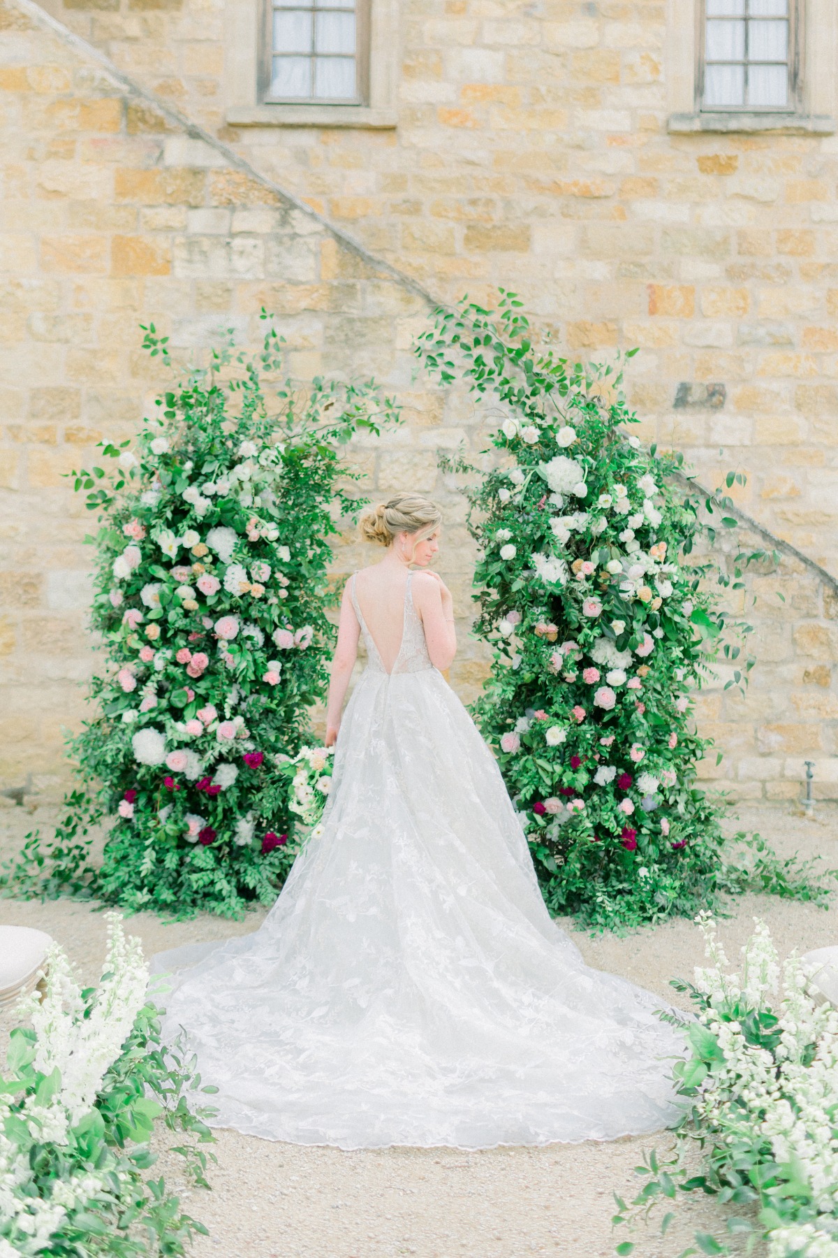 Hailey Paige Bridal wedding gown in front of organic floral backdro[