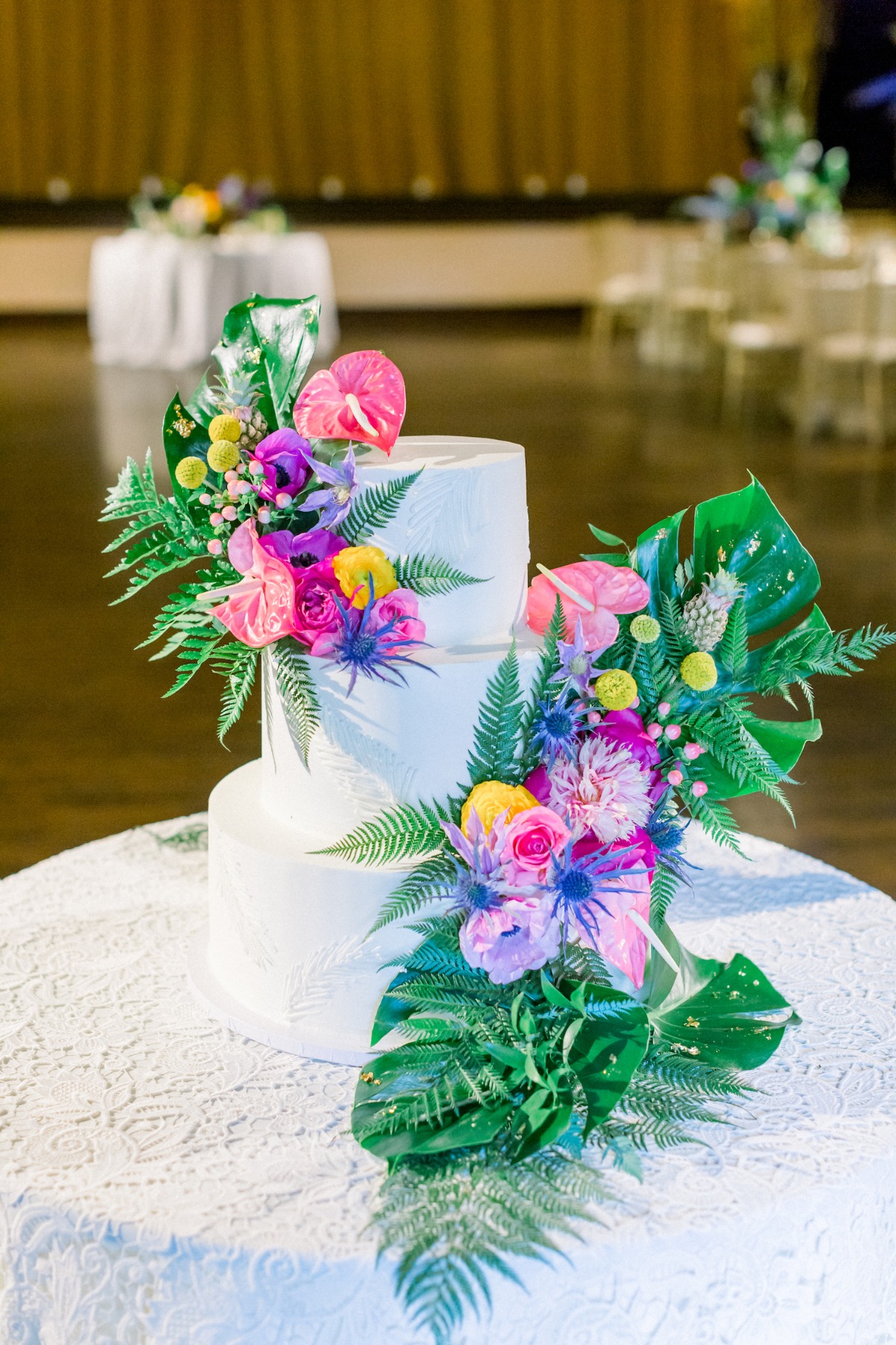 white wedding cake adorned with tropical flowers
