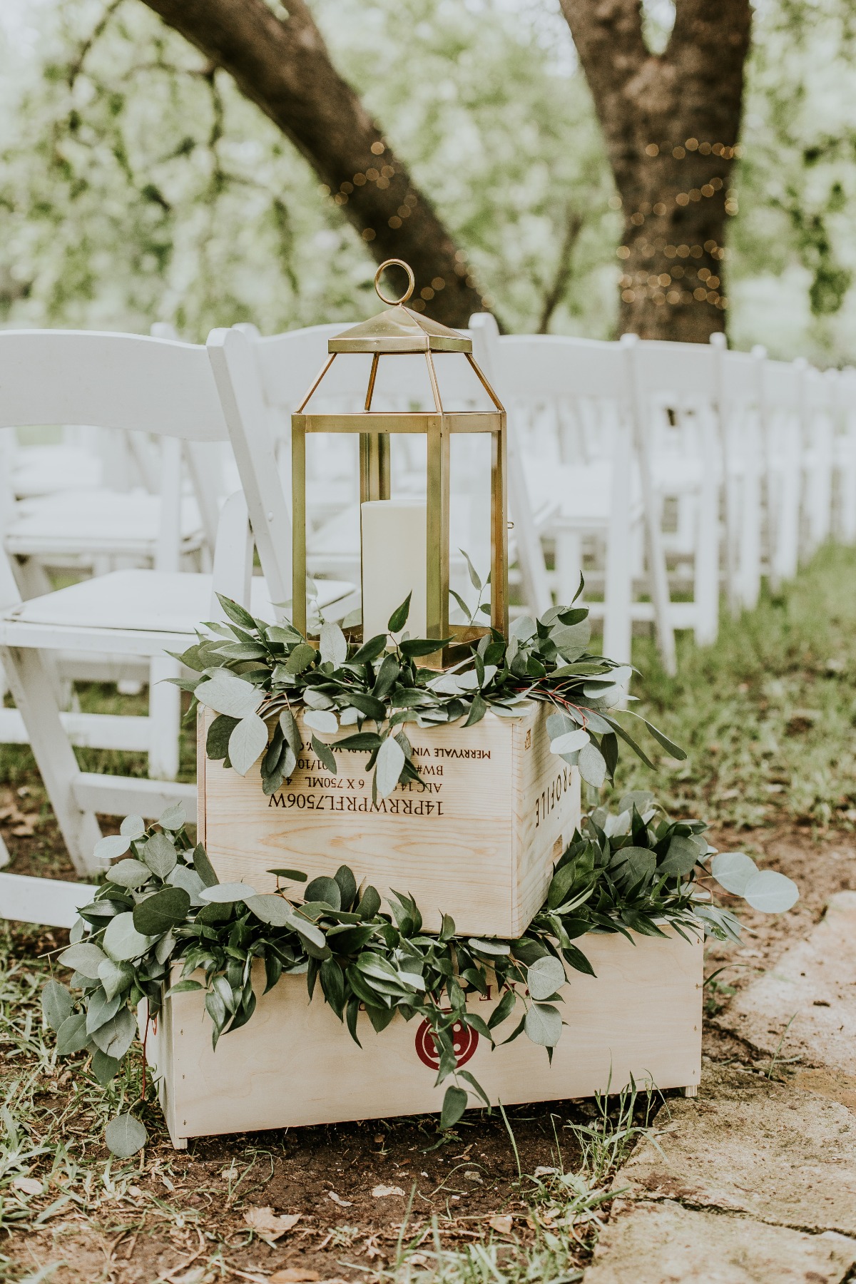 brass lanterns on boxes with greenery used for aisle decor
